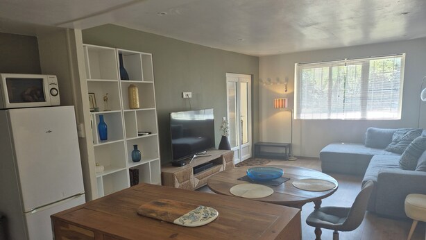 A compact living space with a kitchenette, a dining area, and a seating area. - A 58 m² one-bedroom ground-floor apartment, detached and adjacent to a Provençal villa (Jonquières)