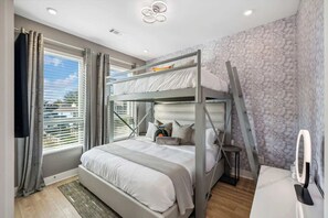 A bunk bed with a desk and chair, a window with curtains, and a patterned wall. - The Nash Bash | Skyline Rooftop + Mins to Downtown (Nashville)