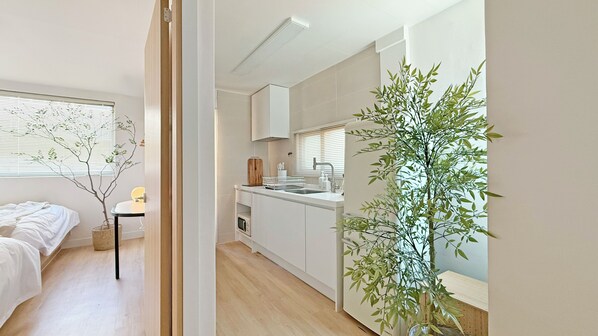 A modern apartment with a kitchen, a dining area, and a bedroom.