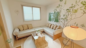 A modern living room with a sofa, a coffee table, and a lamp.