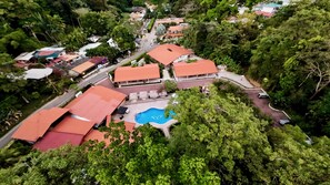 A residential area with multiple houses, a swimming pool, and a road. - Hotel Espadilla Gardens  (Quepos)