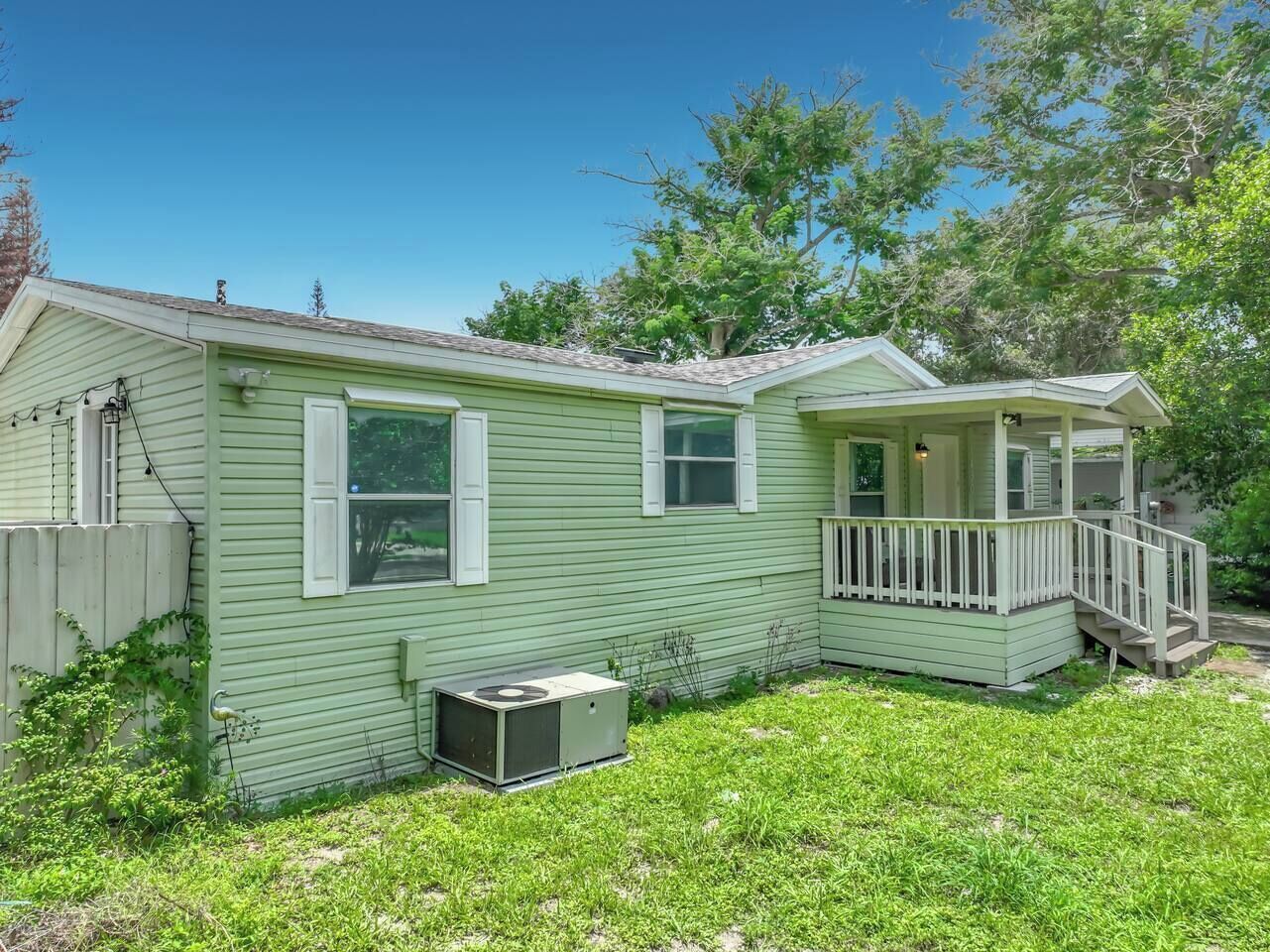 A single-story house with a front porch, a small attached garage, and a yard.