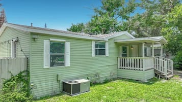 A single-story house with a front porch, a small attached garage, and a yard.