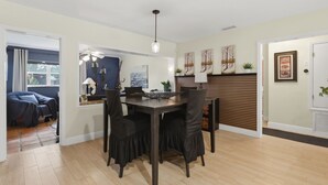 A dining area with a wooden table and chairs, a ceiling fan, and artwork on the walls. - 3-bedroom house in wonderful Winter Park with Big Fenced-In Back Yard! (Winter Park)