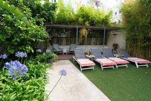 A patio area with lounge chairs, a table, and a covered seating area. - Casa art&co (Palma)