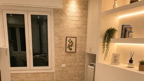 A compact bedroom with a bed, a small seating area, and a window. - Casa nel Bosco – Families & Groups, Jacuzzi (Godiasco Salice Terme)