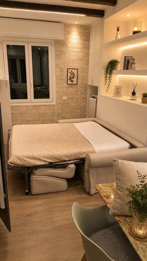 A compact bedroom with a bed, a small seating area, and a window. - Casa nel Bosco – Families & Groups, Jacuzzi (Godiasco Salice Terme)