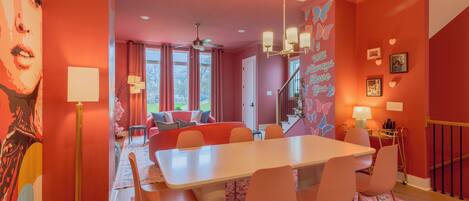 A modern interior with a dining area, a living room with a sofa, and a staircase.