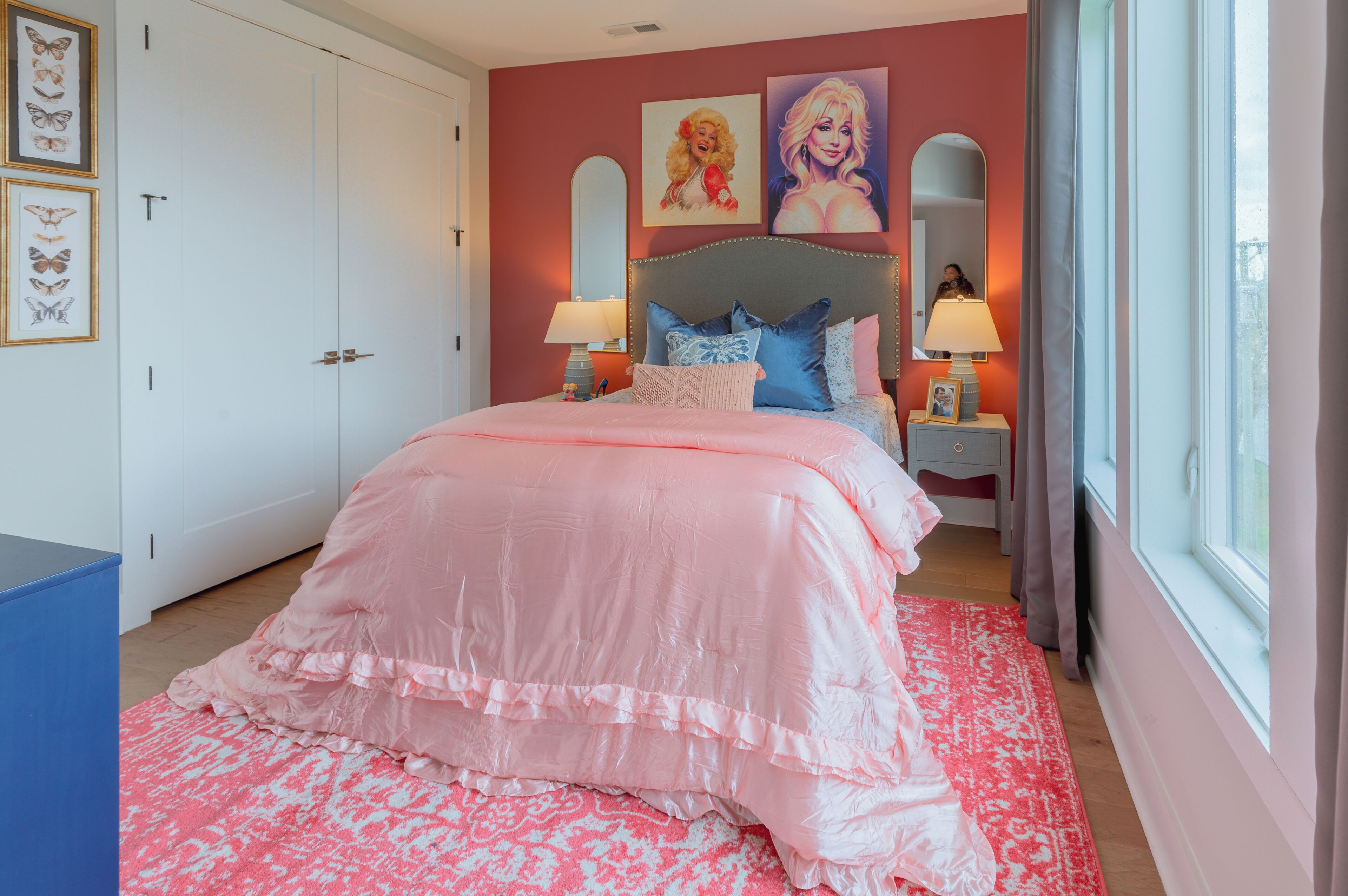Un dormitorio con una cama grande, dos mesitas de noche con lámparas, un armario y una ventana con cortinas.