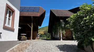 Una calle adoquinada que lleva a un edificio con techo inclinado y paneles solares.