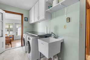 A laundry area with a washing machine, dryer, and sink.