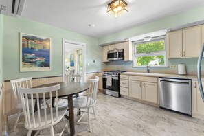 A kitchen with a dining table, chairs, a stove, microwave, oven, and dishwasher. - Prime Rock Hall Location!! Restaurants, Boat Ramp, & Beach Within Minutes Away!! (Rock Hall)