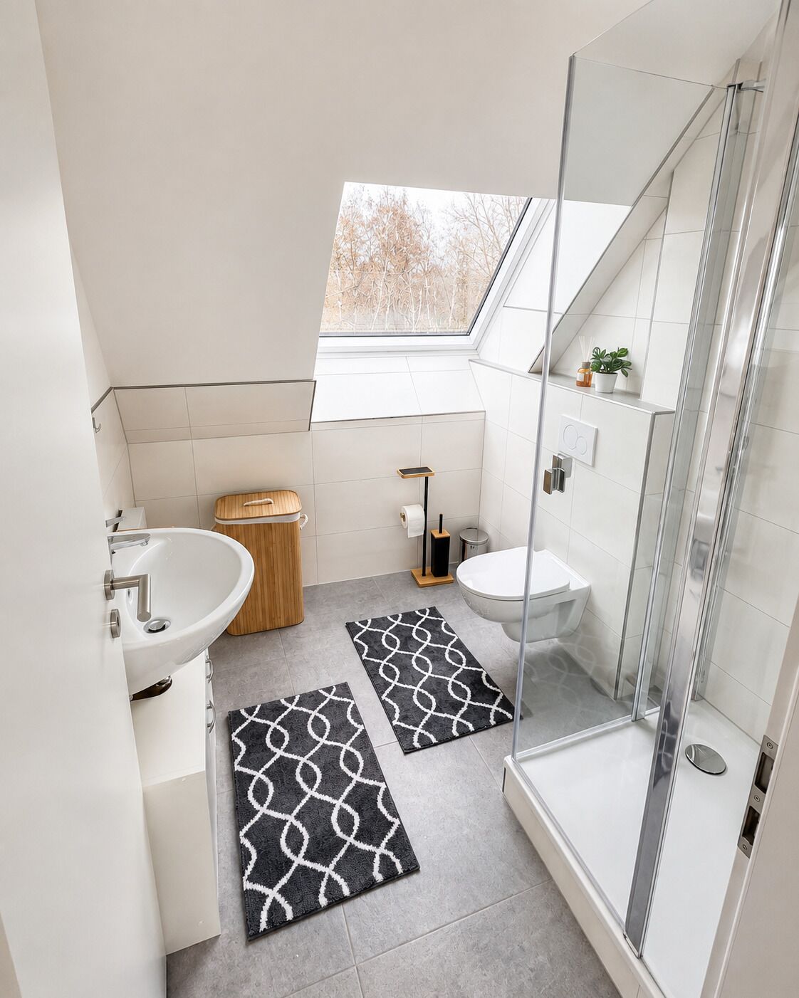 A modern bathroom with a skylight, a shower, a toilet, and a sink.