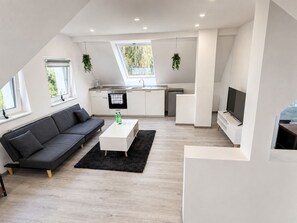 Ein stilvoller Wohnraum mit Sofa, Couchtisch und Flachbildfernseher.