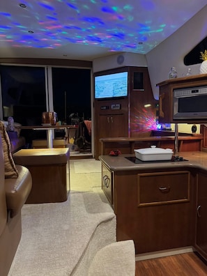 Un espacio habitable pequeño con televisor, armarios de madera y zona de estar.