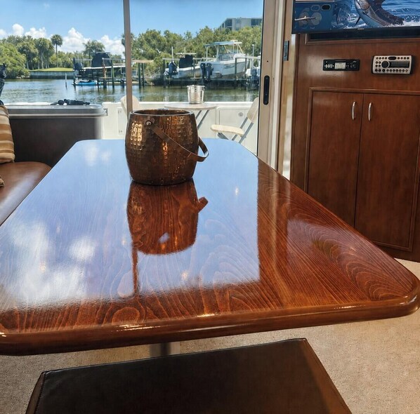 A wooden table with a metal container on it, a cushioned bench, and a view of boats through a window. - AJ‘s Yacht of Fun
Two bedroom luxury 35 foot Yacht (Clearwater)