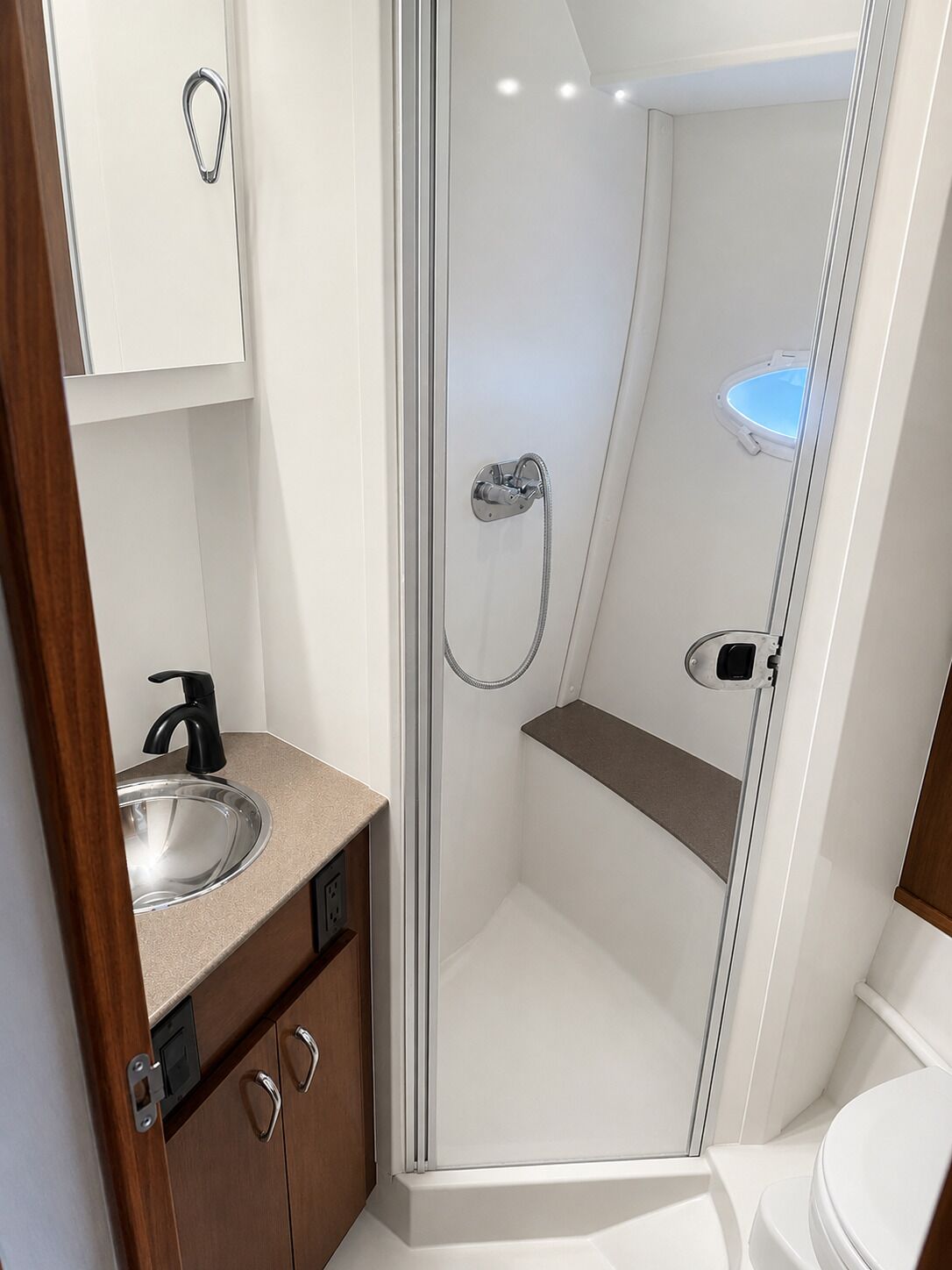 Un baño moderno con ducha de vidrio, lavamanos e inodoro.