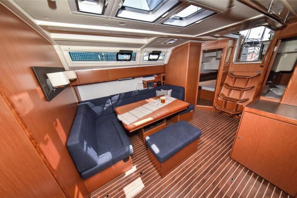 Een compact interieur met een bank, tafel en opbergkasten.