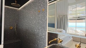 A modern bathroom with a large mirror, a bathtub, and a shower area. - Spacious 3-Bedroom Apartment in a Naturist Village with Ocean Views (Agde)