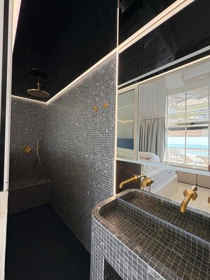Ein modernes Badezimmer mit großem Spiegel, Badewanne und Duschbereich.