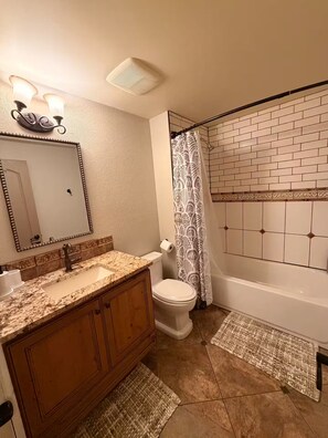 Ein Badezimmer mit Waschtisch, Toilette und Badewanne.