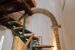 A spiral staircase with wooden steps and metal railings, leading to a stone archway. - Navona - Charming apartment for 4 in the historic Palazzo Massimo (Roma)