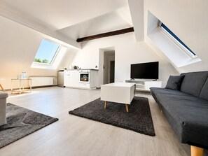 Un moderno loft con angolo cottura, zona giorno e un grande televisore.