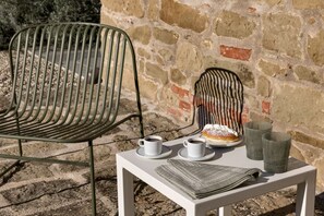 A table with a newspaper, two cups of coffee, a pastry, and two glasses. - Villa Bastia by MMega (San Leo Bastia)