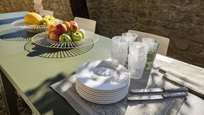 A table set with plates, cutlery, and a fruit bowl. - Villa Bastia by MMega (San Leo Bastia)