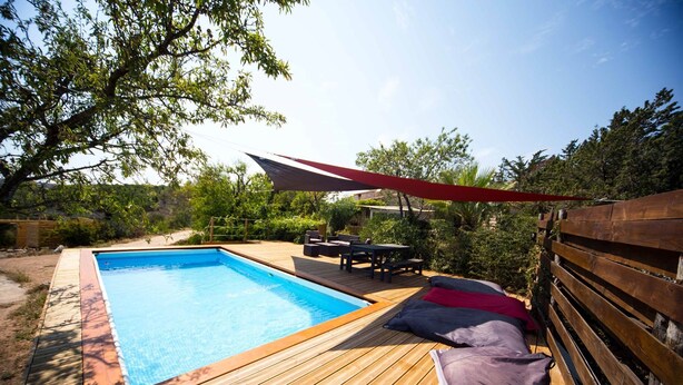 A wooden deck with a swimming pool, outdoor furniture, and a red canopy. - A cozy and unique patio overlooking the ocean (FITOU)