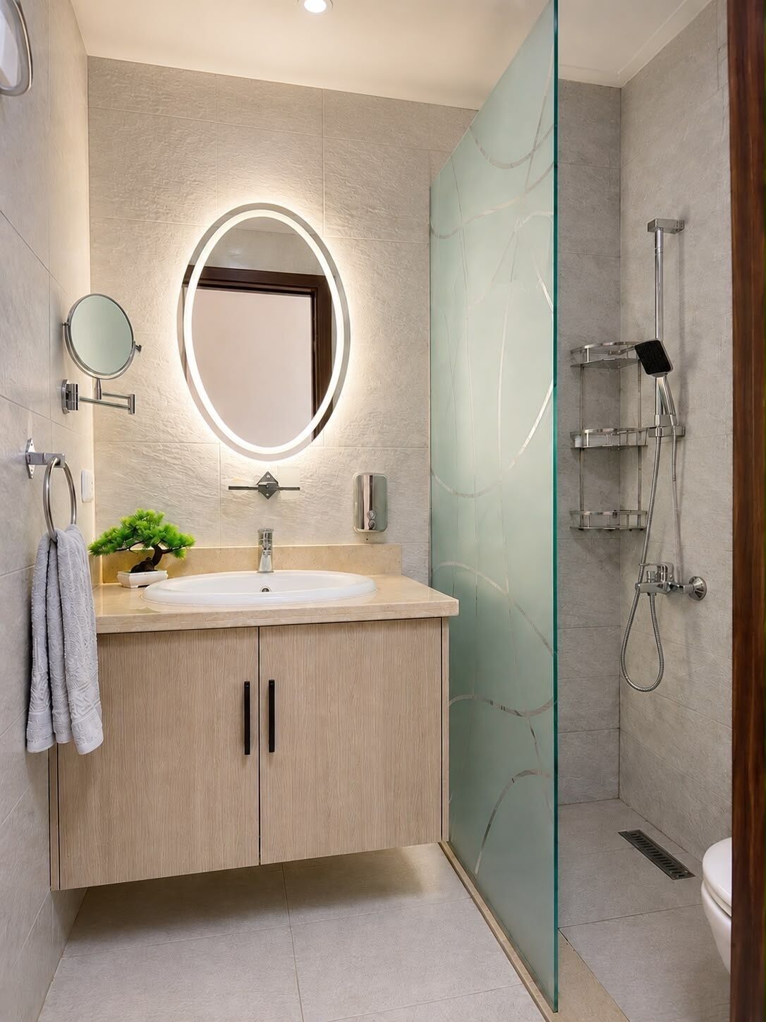 A modern bathroom with a round mirror, a sink, a small plant, and a glass shower enclosure.