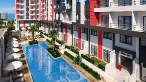 Un hotel moderno con piscina, zona de estar al aire libre y vistas al mar.