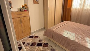 Un dormitorio con cama, armario, espejo y suelo estampado.
