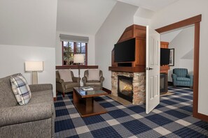 Ein Wohnzimmer mit Kamin, Fernseher und einem Schachbrettmuster auf dem Boden.