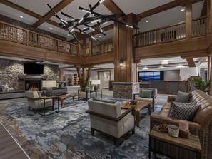 A spacious lobby with a stone fireplace, multiple seating areas, and a high ceiling with exposed beams. - 3 Bedroom Villa Lake Tahoe Grand Residence Resort (South Lake Tahoe)
