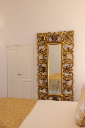 A room with a bed, a white wardrobe, and a large ornate mirror. - Elysora Suite, Divine Sea Views, Outdoor & Indoor Jacuzzi, Santorini (Santorini)