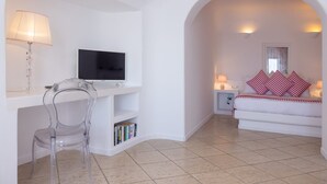 Habitació amb televisió, escriptori, cadira, sofà i finestra.