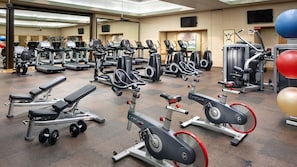 A gym with various exercise equipment including treadmills, elliptical machines, and weight machines. - Beachfront Kaua'i Escape with Ocean Views (Lihue)