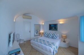 Une chambre à coucher avec un lit, des lampes de chevet, une chaise, un bureau, un miroir et un tableau accroché au mur.
