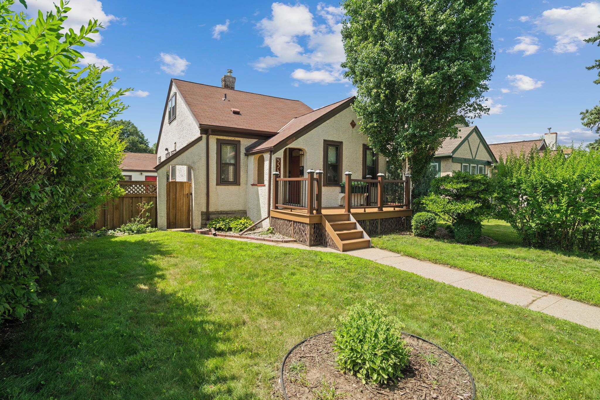A two-story house with a front porch, a visible number '5', and a well-maintained lawn.