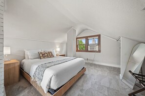 A bedroom with a bed, bedside tables, a window with a view, and a ceiling fan. - Magnolia House (Minneapolis)