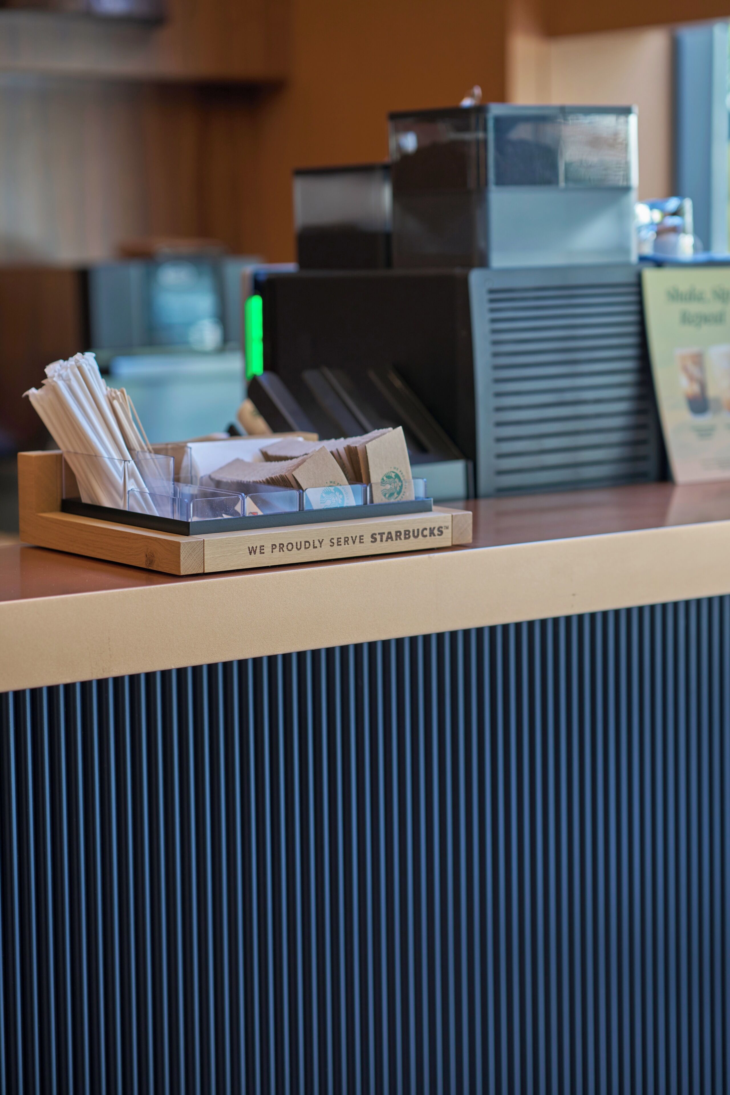 A Starbucks counter with a menu board, a cash register, and a coffee machine.