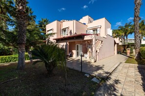 A modern two-story building with a flat roof, surrounded by palm trees and a paved walkway. - Villa Micelli by BarbarHouse (Campomarino)