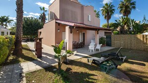 A two-story house with a patio area, outdoor furniture, and a garden. - Villa Micelli by BarbarHouse (Campomarino)