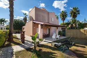 A two-story house with a patio area, outdoor furniture, and a garden. - Villa Micelli by BarbarHouse (Campomarino)