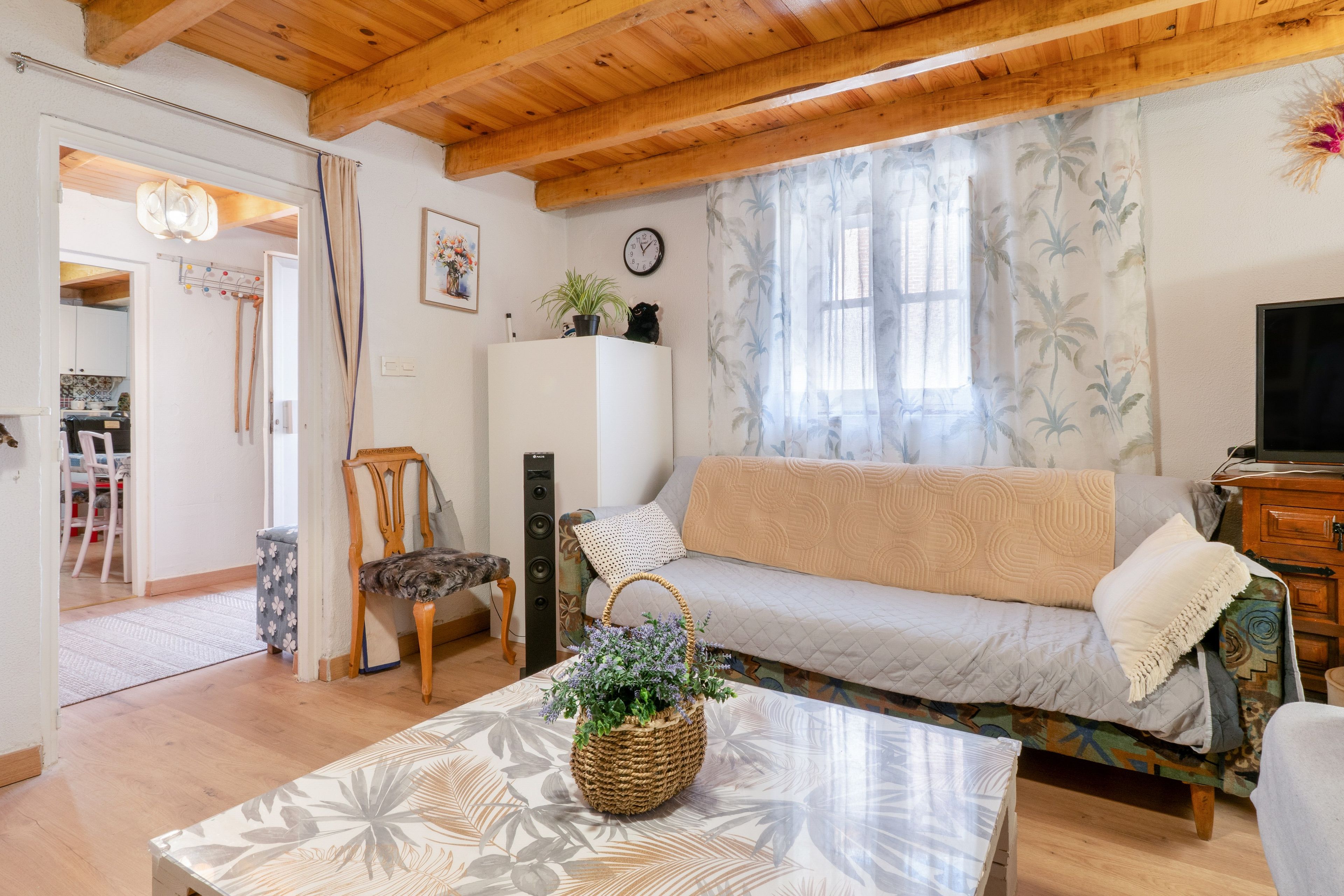 Una sala de estar acogedora con un sofá, una mesa de centro y un televisor.