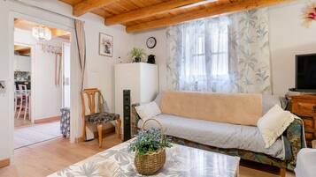 Una sala de estar acogedora con un sofá, una mesa de centro y un televisor.