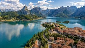 A coastal town with a bridge, a lake, and mountains in the background. - Casa Picos de Europa, Riaño: Rural House with Wi-Fi in a Natural Setting (Valle de las Casas)