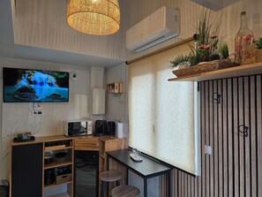 A modern kitchen with a TV, microwave, coffee maker, and a small refrigerator. - Sweety Loft - Accommodation with Spa (Friville-Escarbotin)