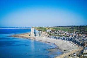 A coastal town with a prominent cliff, a beach, and a dense cluster of buildings. - Sweety Loft - Accommodation with Spa (Friville-Escarbotin)
